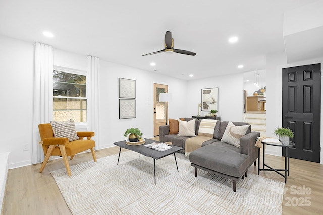 living room featuring light hardwood / wood-style flooring and ceiling fan