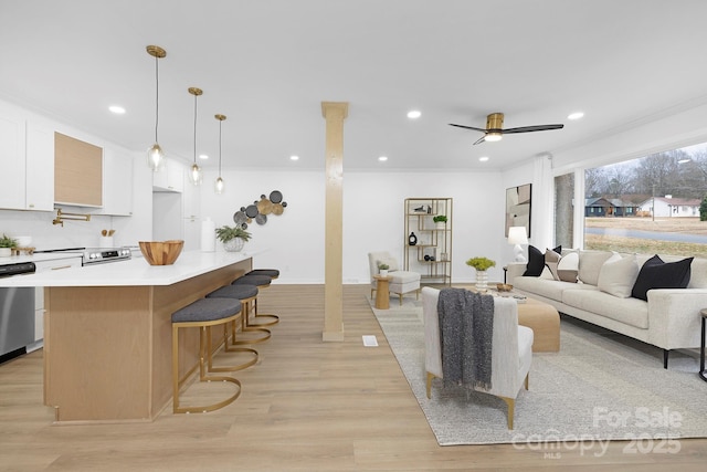 living room with ceiling fan, ornamental molding, and light hardwood / wood-style floors