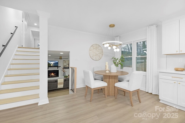 dining area featuring crown molding, a chandelier, and light hardwood / wood-style floors