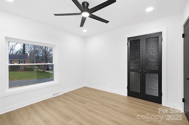 unfurnished bedroom with ceiling fan, a closet, and light hardwood / wood-style flooring