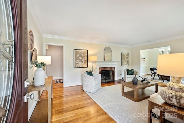 living room with crown molding, a fireplace, and light hardwood / wood-style floors