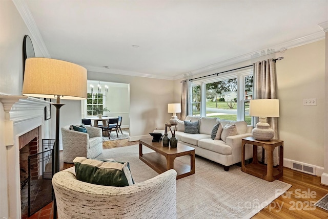 living room featuring a brick fireplace, hardwood / wood-style flooring, and ornamental molding