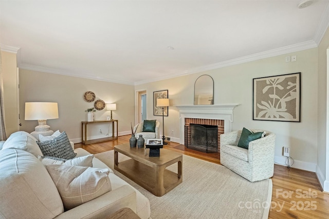 living room with crown molding, a fireplace, and light hardwood / wood-style flooring