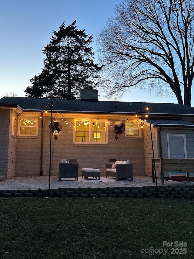 rear view of house featuring a yard, outdoor lounge area, and a patio area