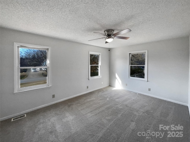 empty room featuring ceiling fan, carpet floors, and a textured ceiling