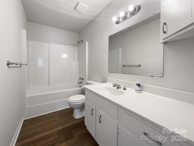 full bathroom featuring toilet, wood-type flooring, a textured ceiling, shower / bathing tub combination, and vanity