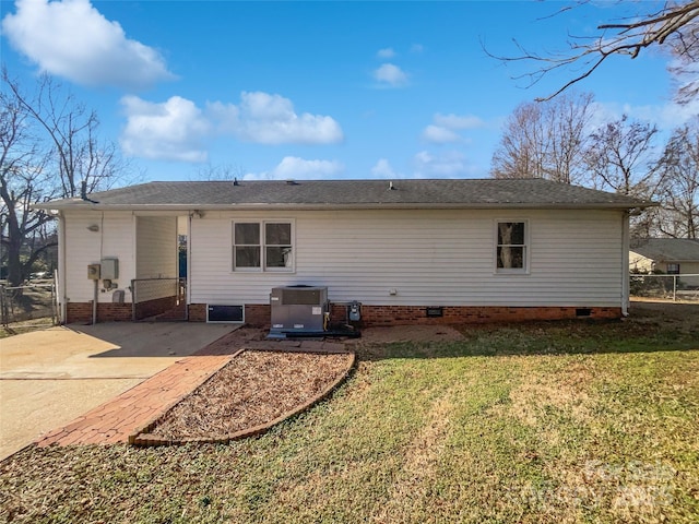 rear view of property with central AC and a lawn