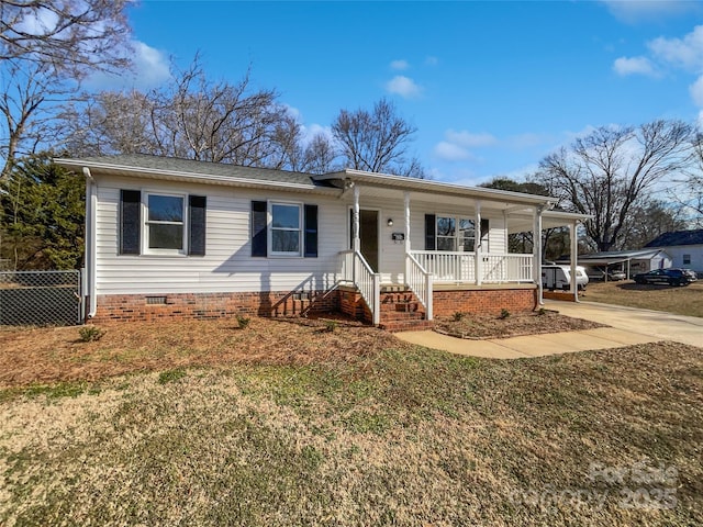 ranch-style house featuring covered porch and a front lawn