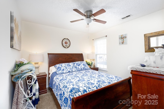 bedroom featuring ceiling fan, a textured ceiling, and carpet flooring