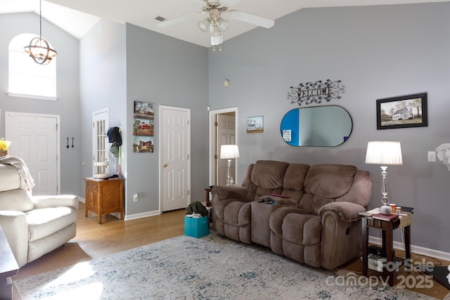 living room with ceiling fan, high vaulted ceiling, and light wood-type flooring