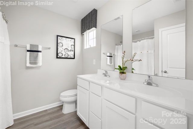 bathroom featuring wood-type flooring, toilet, and vanity