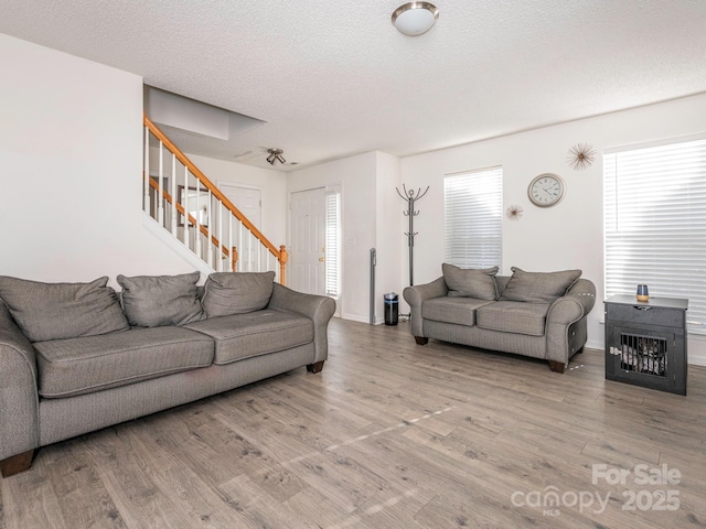 living room with light hardwood / wood-style floors and a textured ceiling