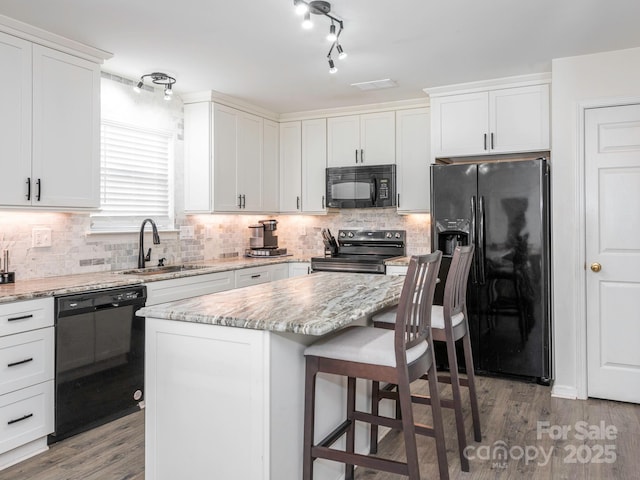 kitchen with white cabinetry, a center island, sink, and black appliances