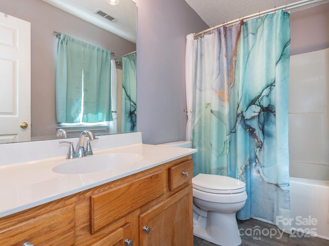 full bathroom with shower / tub combo, vanity, toilet, and a textured ceiling