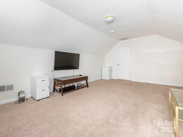 bonus room featuring lofted ceiling, light carpet, and a textured ceiling