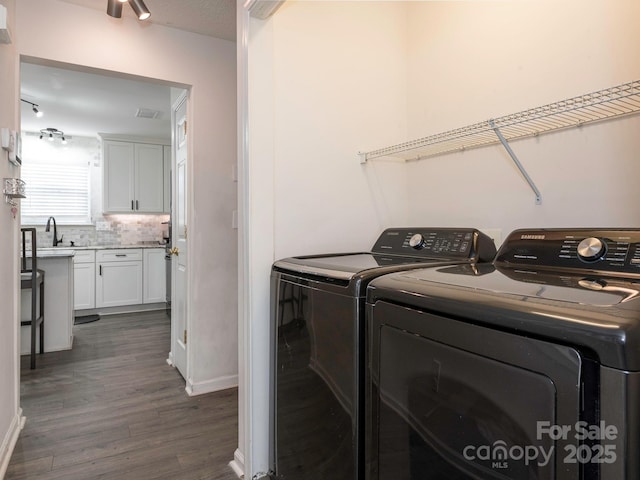 washroom featuring sink, dark hardwood / wood-style flooring, and washing machine and dryer