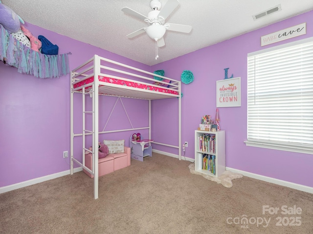 unfurnished bedroom featuring ceiling fan, a textured ceiling, and carpet flooring