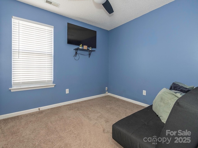 unfurnished room with ceiling fan, carpet, and a textured ceiling