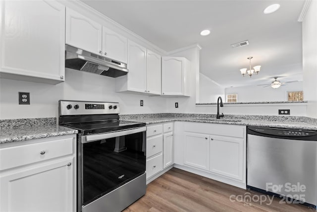 kitchen featuring stainless steel appliances, light stone countertops, sink, and white cabinets