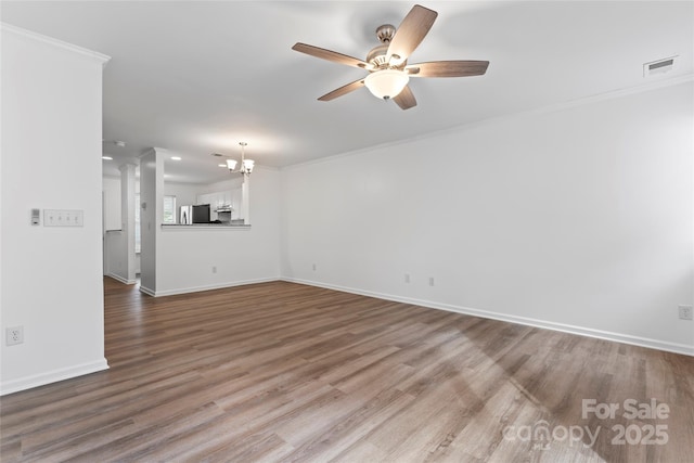 unfurnished living room featuring hardwood / wood-style flooring, crown molding, and ceiling fan with notable chandelier