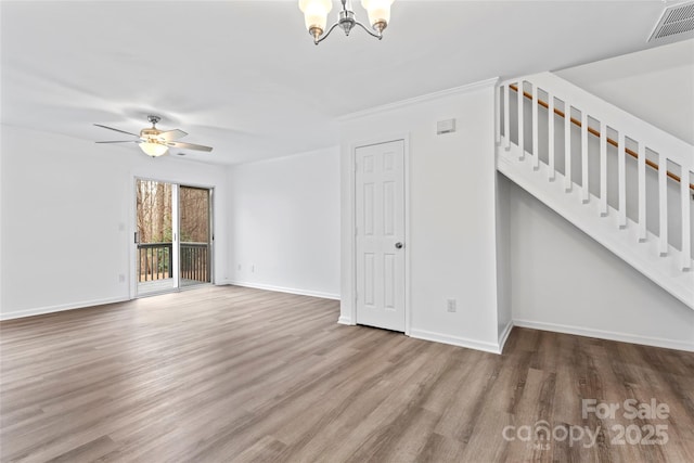 unfurnished living room with ceiling fan with notable chandelier and hardwood / wood-style floors