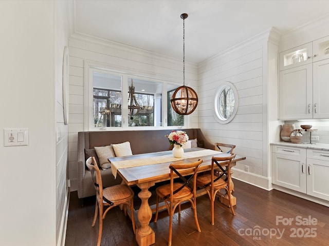 dining room featuring breakfast area, dark wood-type flooring, and ornamental molding