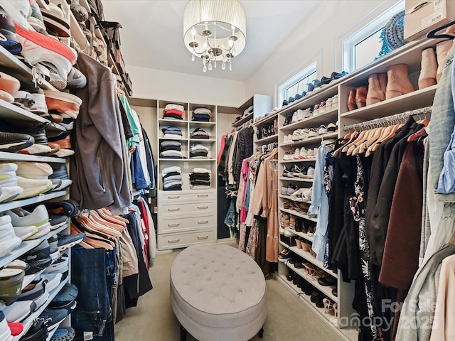 spacious closet with light carpet and a chandelier