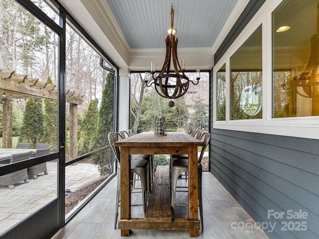 sunroom / solarium featuring a notable chandelier