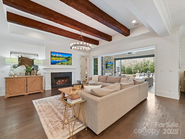 living room with beam ceiling, a fireplace, dark hardwood / wood-style floors, and a chandelier