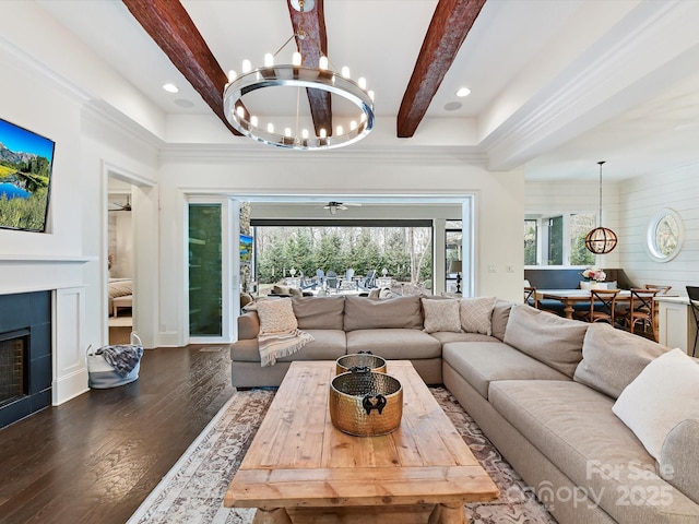 living room with dark hardwood / wood-style floors, a fireplace, a chandelier, and beam ceiling