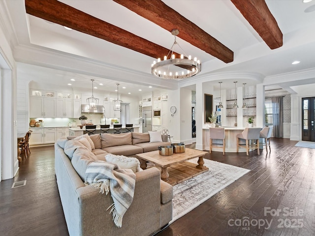 living room with crown molding, beam ceiling, dark wood-type flooring, and a chandelier