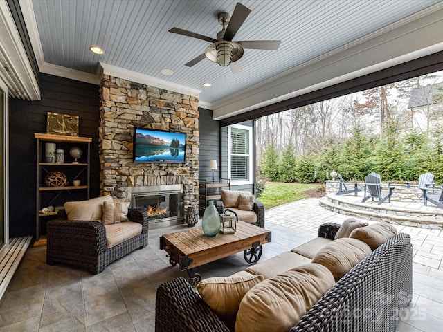 view of patio / terrace featuring ceiling fan, an outdoor living space with a fireplace, and a baseboard radiator