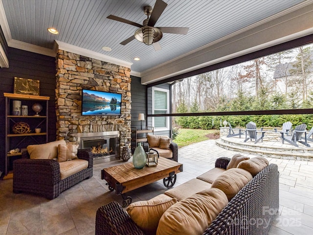 interior space featuring wood ceiling, crown molding, an outdoor stone fireplace, and ceiling fan