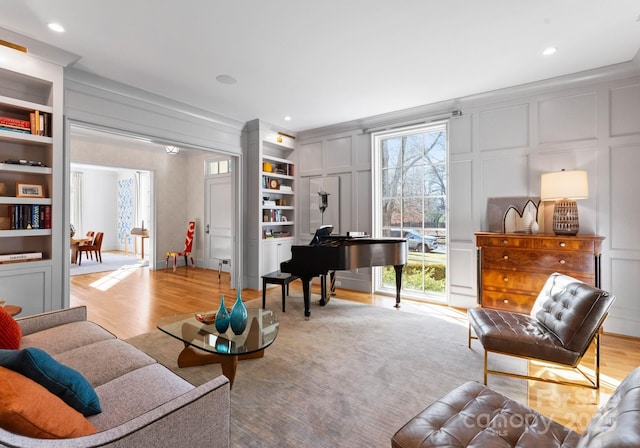 living area featuring plenty of natural light, light wood-type flooring, and built in shelves