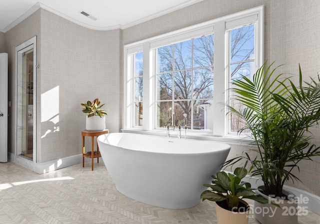 bathroom featuring crown molding and a bathing tub