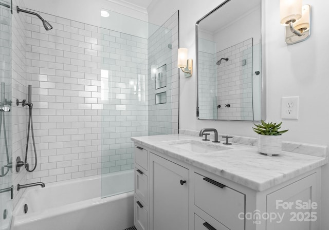 bathroom featuring crown molding, tiled shower / bath, and vanity