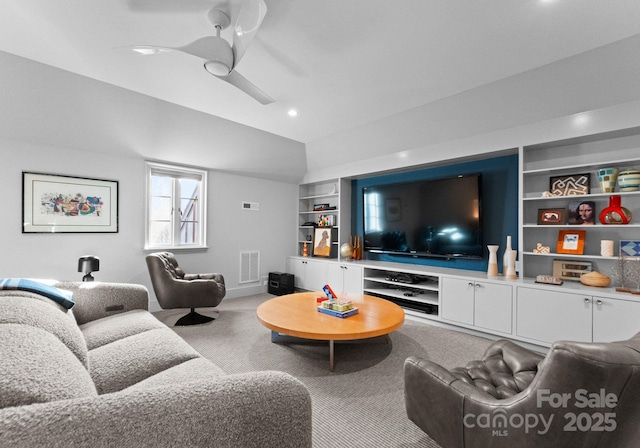 carpeted living room featuring ceiling fan, vaulted ceiling, and built in features