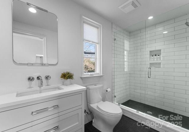 bathroom with vanity, toilet, and a shower with door