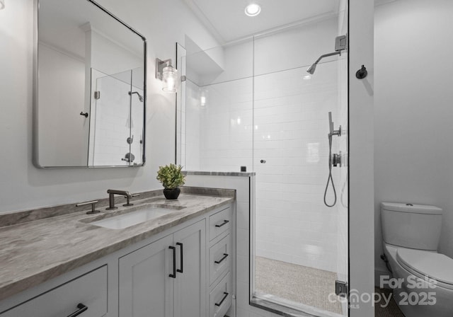 bathroom featuring vanity, toilet, and a shower with shower door