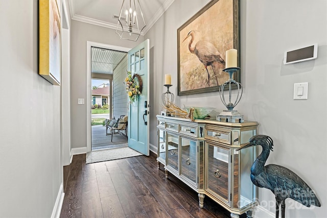 entryway with an inviting chandelier, ornamental molding, and dark hardwood / wood-style floors