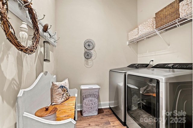 laundry area with wood-type flooring and washer and clothes dryer