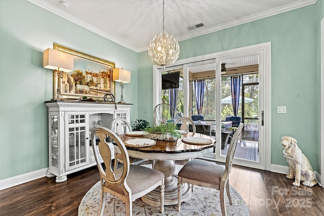 dining room with a fireplace, ornamental molding, dark hardwood / wood-style flooring, and a notable chandelier