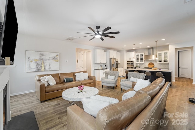 living room featuring ceiling fan and light hardwood / wood-style flooring