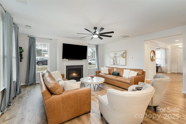 living room featuring plenty of natural light, light hardwood / wood-style floors, and ceiling fan