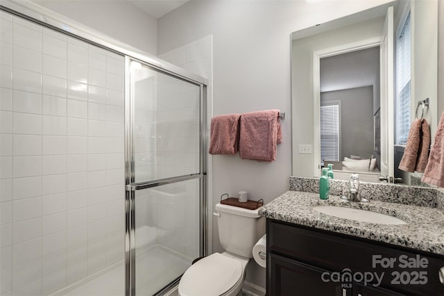 bathroom featuring vanity, toilet, and walk in shower