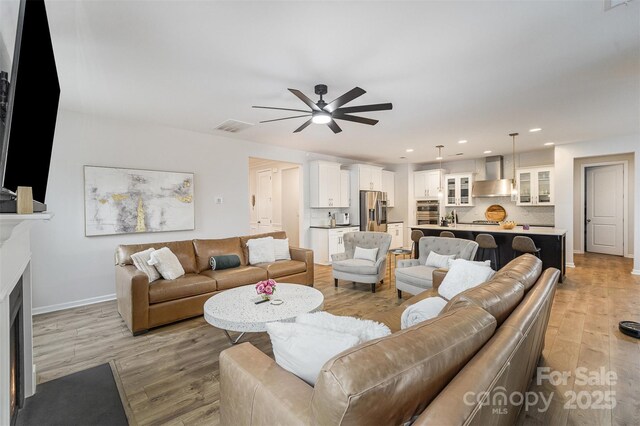 living room with ceiling fan and light wood-type flooring