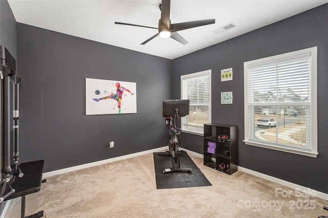 workout area featuring light colored carpet and ceiling fan