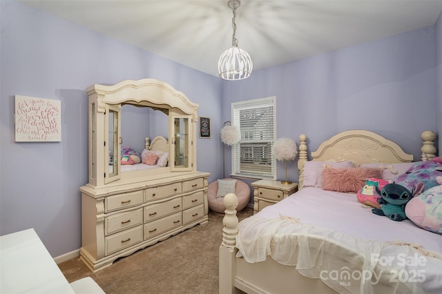 carpeted bedroom with an inviting chandelier