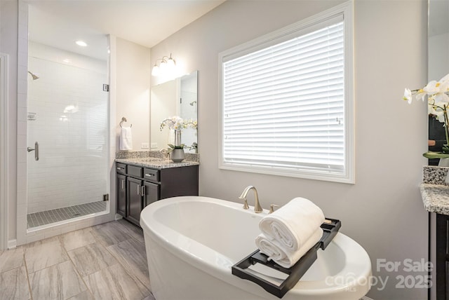 bathroom featuring vanity, plenty of natural light, and separate shower and tub