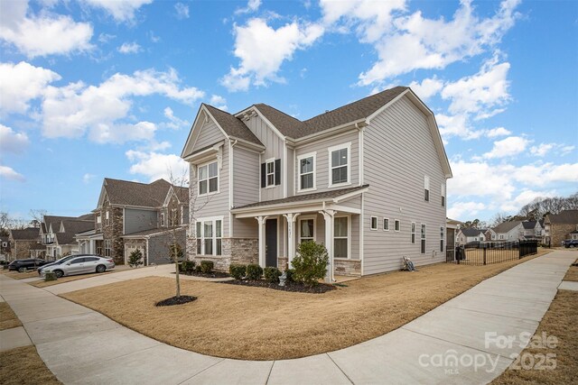 view of front of property with a garage, a front lawn, and covered porch